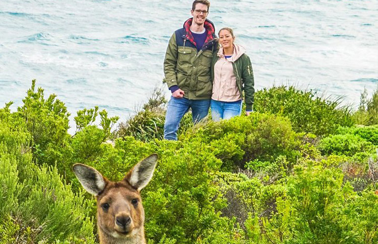 Kangaroo photo bombing a couple on a cliff top